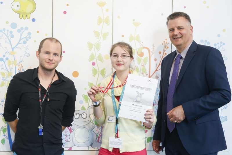 v.re.: Dienstleiter für Öffentlichkeitsarbeit Rudolf Gollia, Schülerin Katharina Schwab und Lehrer Philipp Brunner bei der Urkunden- und Medaillenübergabe