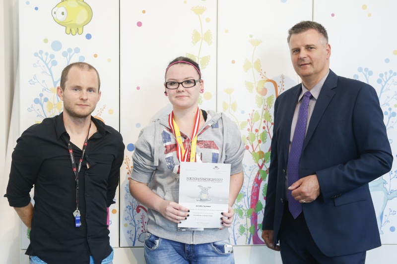 v.re.: Dienstleiter für Öffentlichkeitsarbeit Rudolf Gollia, Schülerin Jennifer Sommer und Lehrer Philipp Brunner bei der Urkunden- und Medaillenübergabe
