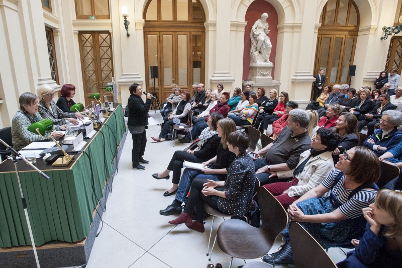 Blick in Richtung VeranstaltungsteilnehmerInnen. Podium v.li.: Pädagogin Erna Dittelbach, Herausgeberin Käthe Kratz und die ehemalige Herausgeberin 'AUF' Dagmar Klopf. Autorin Eva Dité (stehend) bringt eine musikalische Darbietung