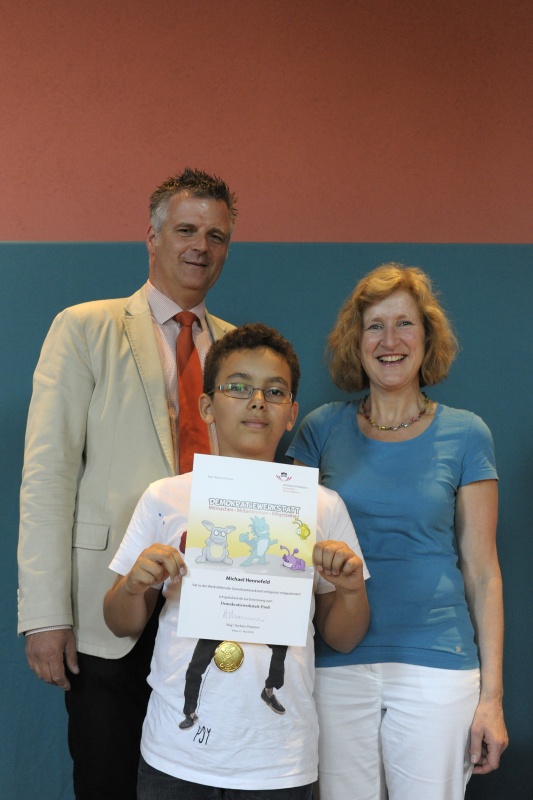 v.li.: Dienstleiter für Öffentlichkeitsarbeit Rudolf Gollia, Schüler Michael Hennefeld und Lehrerin Claudia Listabarth bei der Urkunden- und Medaillenübergabe
