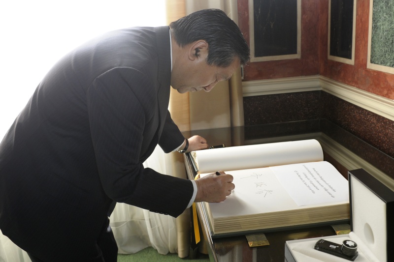 Der Vizepräsident der politischen Konsultativkonferenz des chinesischen Volks Qi Xuchun beim Eintrag in das Gästebuch