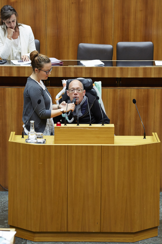 Nationalratsabgeordneter Franz-Joseph Huainigg (V) am Rednerpult. Im Hintergrund auf der Regierungsbank Familienministerin Sophie Karmasin (V).