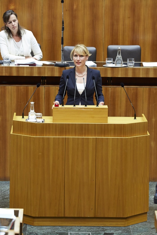 Klubobfrau Kathrin Nachbaur (T) am Rednerpult. Im Hintergrund auf der Regierungsbank Familienministerin Sophie Karmasin (V)