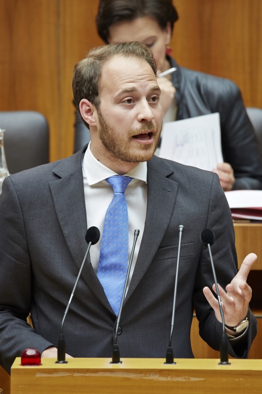 Nationalratsabgeordneter Nikolaus Scherak (N) am Rednerpult. Im Hintergrund auf der Regierungsbank Unterrichtsministerin Gabriele Heinisch-Hosek (S).