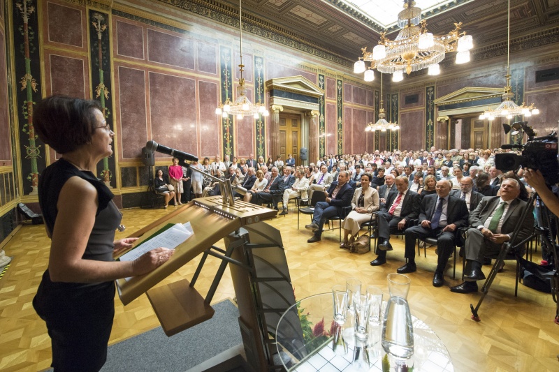 Bundesratspraesidentin Ana Blatnik (S) bei der Begrüssung am Rednerpult. Blick in Richtung VeranstaltungsteilnehmerInnen.