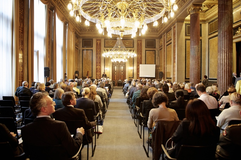 Blick Richtung VeranstaltungsteilnehmerInnen mit Parlamentsdirektor Harald Dossi am Rednerpult