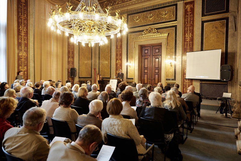 Blick Richtung VeranstaltungsteilnehmerInnen mit Parlamentsdirektor Harald Dossi am Rednerpult