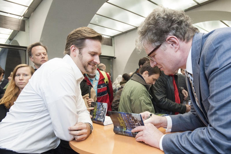 Roger Willemsen (re.) signiert sein Buch