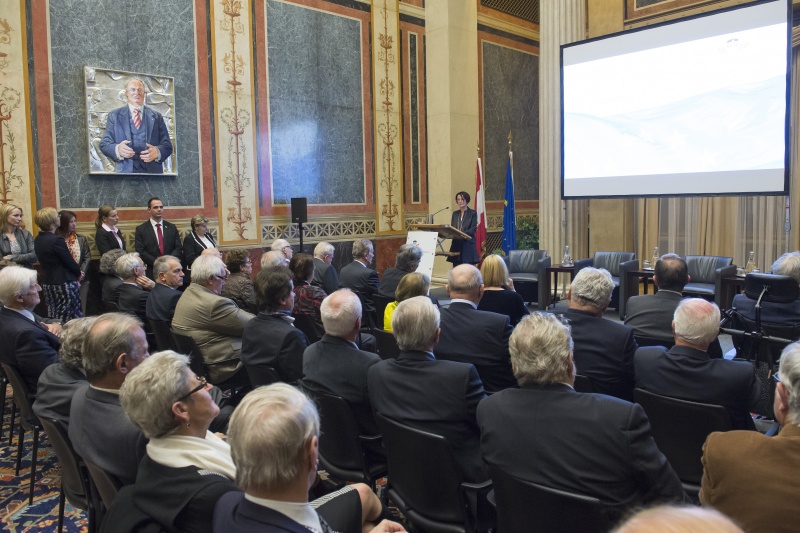 Bundesratspräsidentin Ana Blatnik (S) bei ihrer Ansprache am Rednerpult. Blick Richtung VeranstaltungsteilnehmerInnen