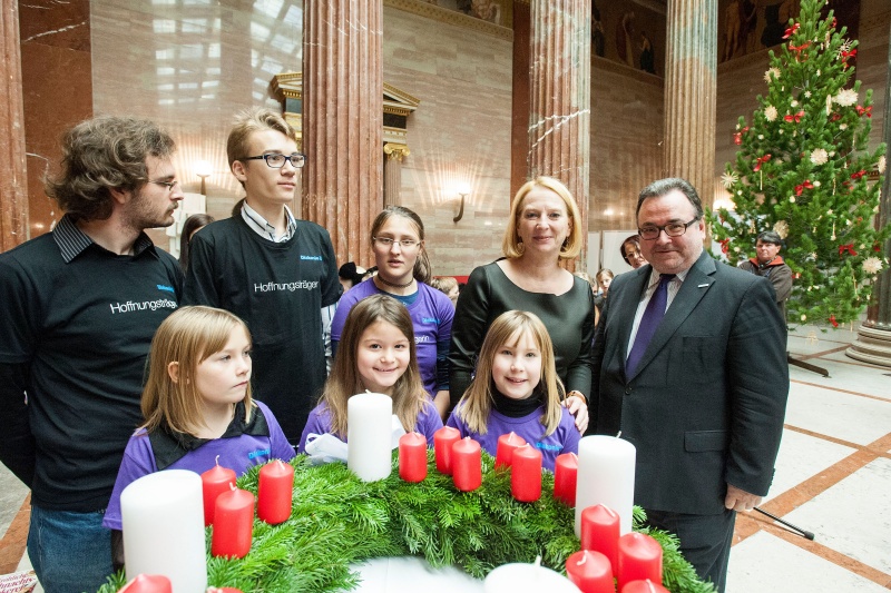 Nationalratspräsidentin Doris Bures (S) und Direktor der Diakonie Österreich Michael Chalupka (re.) mit Kindern des Chores der Johann Sebastian Bach Musikschule am Karlsplatz vor dem Adventkranz