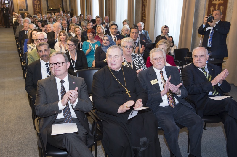 Erste Reihe v.li.: Zweiter Nationalratspräsident Karlheinz Kopf (V), Prälat Maximilian Fürnsinn, LCI Repräsentant bei der UNO PID Dir. Ernst A.ÊMusil und ein  Veranstaltungsteilnehmer. Blick Richtung VeranstaltungsteilnehmerInnen