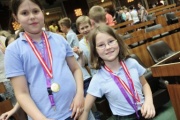 Zwei SchülerInnen zeigen stolz ihre Medaillen