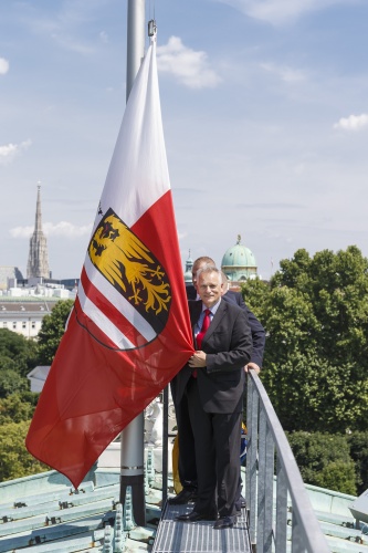 Bundesratspräsident Gottfried Kneifel (V) und Parlamentsbedienstete beim Hissen der Fahne Oberösterreichs am Parlamentsdach