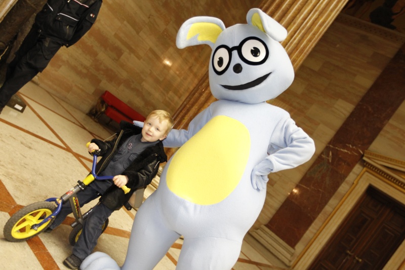 Demokratiewerkstattmaskottchen mit einem jungen Besucher