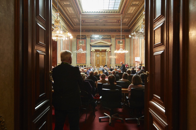 Johannes Kyrle am Rednerpult. Blick Richtung VeranstaltungsteilnehmerInnen