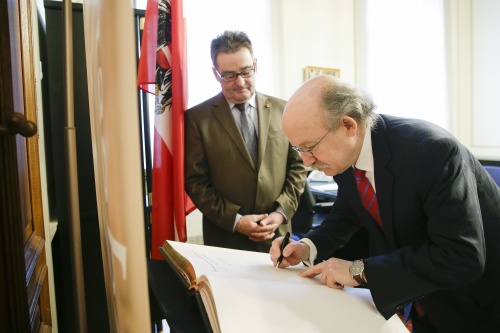 von rechts: Der chilenische Botschafter Armin Andereya bei seinem Eintrag ins Gästebuch