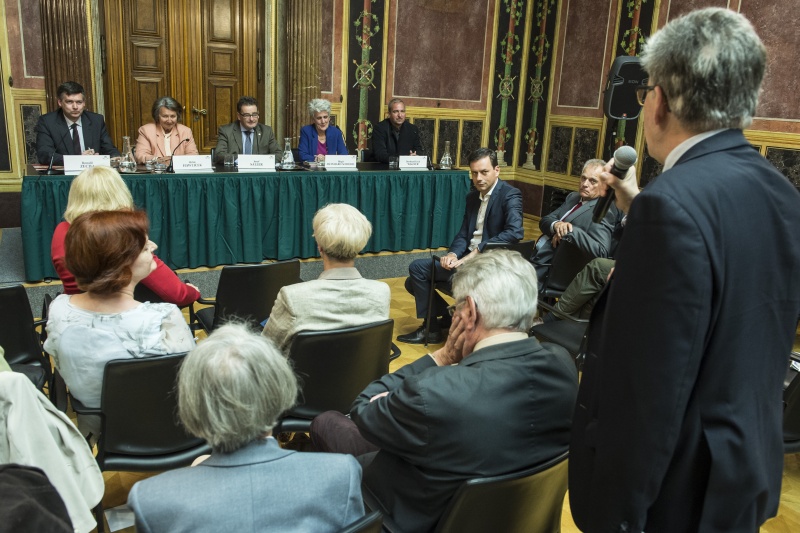 Podium von links: Leiter der Volkshochschule Tirol Ronald Zecha, Bundesministerin a.D. Hilde Hawlicek, Bundesratspräsident Josef Saller (V), Gemeinderätin Birgit Meinhard-Schiebel, Geschäftsführer CURRIT Institut Bernhard Erich Wagner. Ein Veranstaltungsteilnehmer bei seiner Wortmeldung