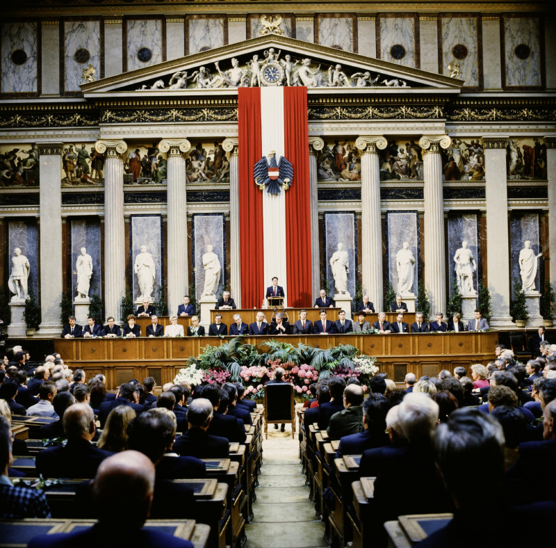 Blick Richtung Regierungsbank und Präsidium während der Eröffnungsansprache von Nationalratspräsident Heinz Fischer (S).

Am Präsidium von links: Bundesratsvizepräsident Herbert Schambeck (V), Dritter Nationalratspräsident Herbert Haupt (F), Bundesratspräsident Jürgen Weiss (V), Nationalratspräsident Heinz Fischer (S), Zweiter Nationalratspräsident Heinrich Neisser (V), Bundesratsvizepräsident  Walter Strutzenberger (S), Parlamentsdirektor Heinz Wasserbauer.
Auf der Regierungsbank von links: Staatssekretär im Bundeskanzleramt Gerhard Schäffer (V), Staatssekretär im Bundesministerium für Öffentliche Wirtschaft und Verkehr Martin Bartenstein (V), Staatssekretär im Bundesministerium für Finanzen Johannes Ditz (V), Familienministerin Sonja Moser (V), Verteidigungsminister Werner Fasslabend (V), Gesundheitsministerin Christa Krammer (S), Umweltministerin Maria Rauch-Kallat (V), Wirtschaftsminister Wolfgang Schüssel (V), Außenminister Alois Mock (V), Vizekanzler und Unterrichtsminister Erhard Busek (V), Bundeskanzler Franz Vranitzky (S), Innenminister Caspar Einem (S), Verkehrsminister Viktor Klima (S), Finanzminister Andreas Staribacher, Frauenministerin Helga Konrad (S), Sozialminister Franz Hums (S), Justizminister Nikolaus Michalek, Wissenschaftsminister Rudolf Scholten (S), Landwirtschaftsminister Wilhelm Molterer (V), Staatssekretärin im Bundeskanzleramt Brigitte Ederer (S), Staatssekretär im Bundeskanzleramt Karl Schlögl (S).
