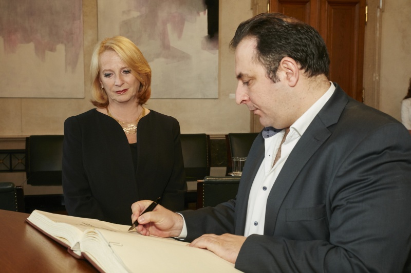 President des syrischen Center for Media and Freedom of Expression Mazen Darwish beim Eintrag in das Gästebuch. Im Hintergrund Nationalratspräsidentin Doris Bures (S)