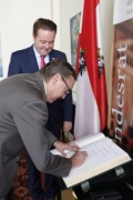 Der Russische Botschafter Dmitri Ljubinski beim Eintrag in das Gästebuch, dahinter Bundesratspräsident Mario Lindner (S)