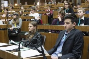 SchülerInnen  im Plenum auf den Sitzplätzen der Nationalratsabgeordneten