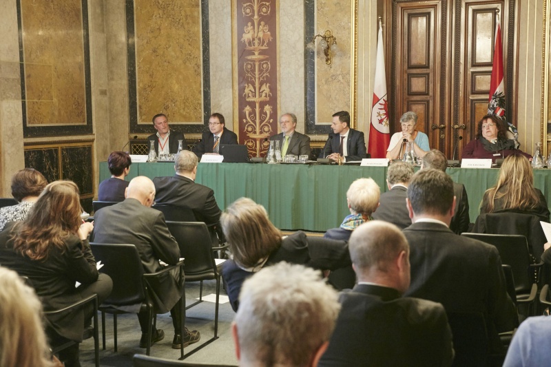 Podium von rechts: Bernadette Feuerstein Selbstbestimmtes Leben Österreich, Uli Makomaski pflegende Angehörige, Vizepräsident des Bundesrates Ernst Gödl (V), Parlamentsdirektion Gerhard Kiesenhofer, Geschäftsführer Walter Marschitz Sozialwirtschaft Österreich und Gerald Möderl Gesundheits- und Krankenpfleger. Blick Richtung VeranstaltungsteilnehmerInnen