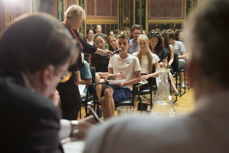 Blick Richtung VeranstaltungsteilnehmerInnen. Schüler bei seiner Wortmeldung