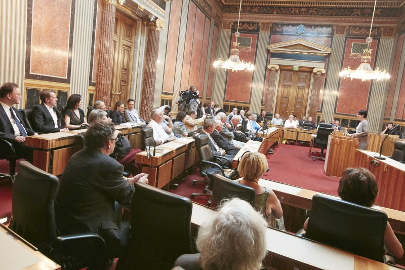 Begrüßung durch Bundesratspräsidentin Sonja Ledl-Rossmann (V) am Rednerpult. Blick Richtung VeranstaltungsteilnehmerInnen