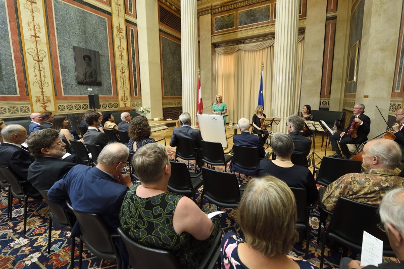 Begrüßung durch Nationalratspräsidentin Doris Bures (S) am Rednerpult. Blick Richtung VeranstaltungsteilnehmerInnen