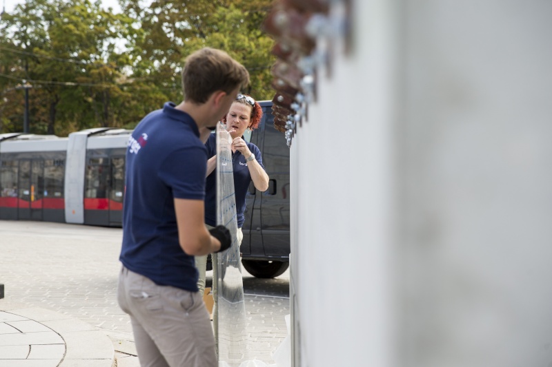 MitarbeiterInnen der Firma Berger beim Befestigen der Bautafel