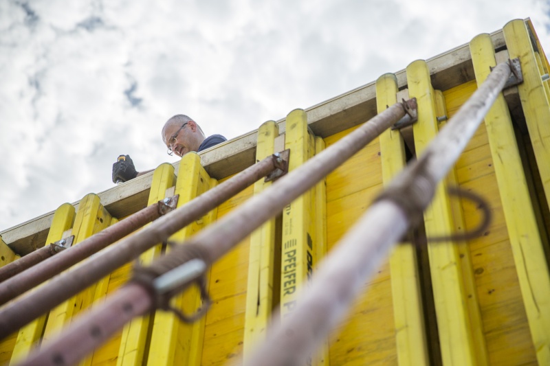 MitarbeiterInnen der Firma Berger beim Befestigen der Bautafel