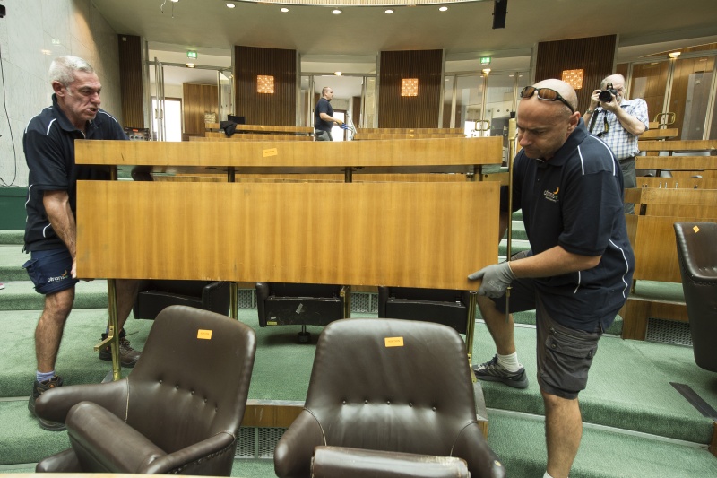 Arbeiter beim Entfernen der Arbeitsplätze der Nationalratsabgeordneten