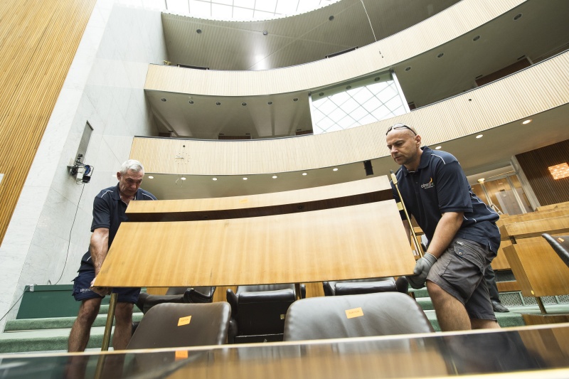 Arbeiter beim Entfernen der Arbeitsplätze der Nationalratsabgeordneten