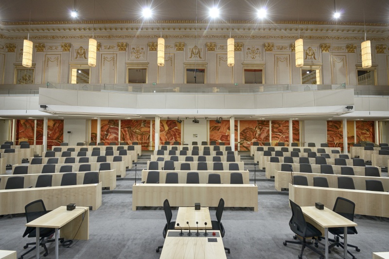 Frontalansicht des Plenarsaals von National- und Bundesrat im Großen Redoutensaal in der Hofburg mit Bildern von Josef Mikl. Blick vom Präsidium in Richtung Abgeordnetensitzplätze und Besuchertribüne