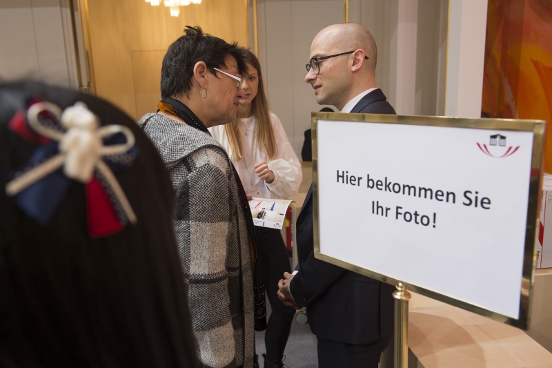 Blick Richtung VeranstaltungsteilnehmerInnen. Besucher bekommen ihr ausgedrucktes Foto