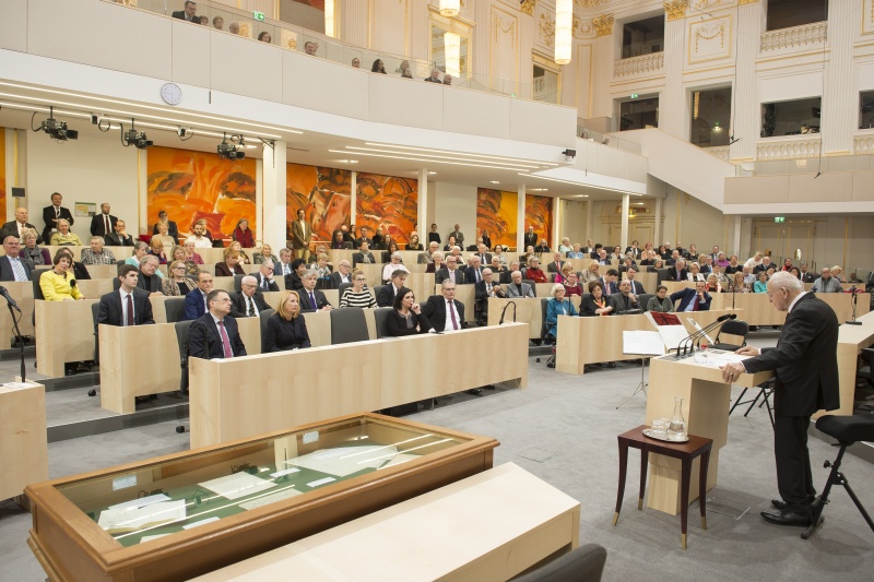 Blick Richtung VeranstaltungsteilnehmerInnen. Erste Reihe von links: Klubobmann August Wöginger (V), Zweite Nationalratspräsidentin Doris Bures (S), Nationalratspräsidentin Elisabeth Köstinger (V), Bundesratspräsident Edgar Mayer (V).  Am Rednerpult: Univ.-Prof. Dr. Gerald Stourzh