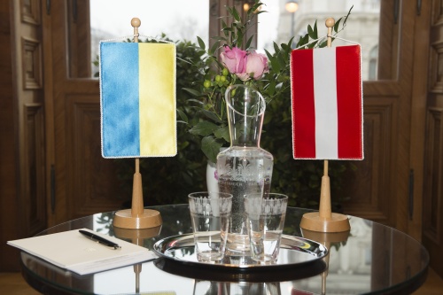 Tisch mit Nationalflaggen der Ukraine und Österreichs