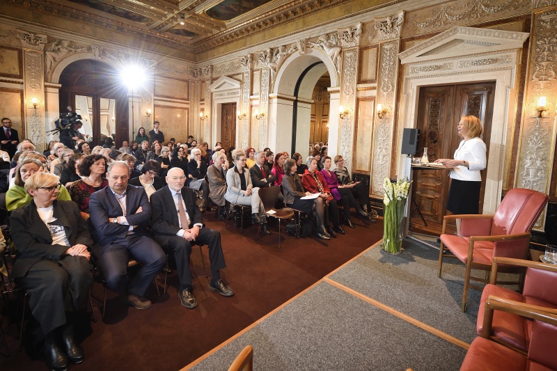 Begrüßung durch die Zweite Nationalratspräsidentin Doris Bures (S) am Rednerpult. Blick Richtung VeranstaltungsteilnehmerInnen