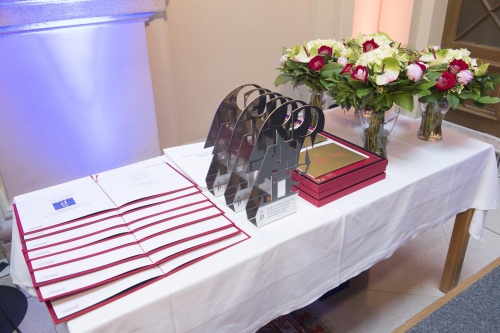 Tisch mit den Staatspreisen KnewLEDGE und Blumen