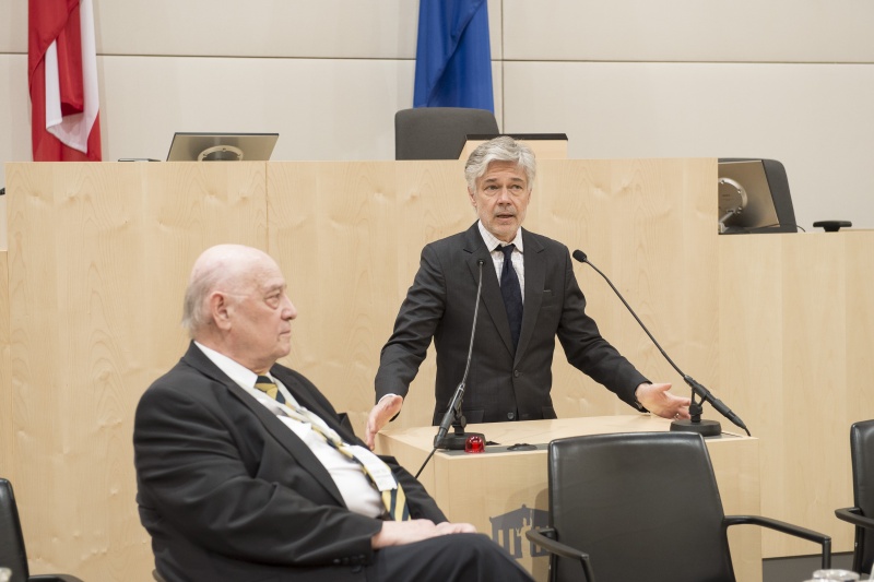 Begrüßung druch Parlamentsdirektor Harald Dossi am Rednerpult. Am Podium: Anton Salesny, Programmkoordinator