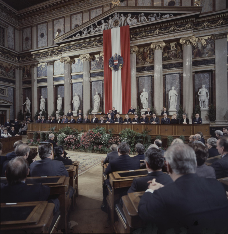 Blick Richtung Präsidium und Regierungsbank während der Ansprache von Nationalratspräsident Anton Benya (S) (am Rednerpult).

Am Präsidium von links: Bundesratsvizepräsident Herbert Schambeck (V), Dritter Nationalratspräsident Gerulf Stix (F), Bundesratspräsident Helmut Frauscher (V), Zweiter Nationalratspräsident Roland Minkowitsch (V), Bundesratsvizepräsident Hellmuth Schipani (S), Parlamentsdirektor Wilhelm Czerny

In der Regierungsbank von links: Staatssekretär im Bundesministerium für Land- und Forstwirtschaft Gerulf Murer (F), Bundesminister für öffentliche Wirtschaft und Verkehr Ferdinand Lacina (S), Staatssekretär im Bundesministerium für Gesundheit und Umweltschutz Mario Ferrari-Brunnenfeld, Staatssekretär im Bundesministerium für Finanzen Holger Bauer (F), Staatssekretärin im Bundeskanzleramt Johanna Dohnal (S), Staatssekretär im Bundeskanzleramt Franz Löschnak (S), Bundesminister für Landesverteidigung Friedhelm Frischenschlager (F), Bundesminister für Wissenschaft und Forschung Heinz Fischer (S), Bundesminister für Auswärtige Angelegenheiten Leopold Gratz (S), Vizekanzler und Handelsminister Norbert Steger (F), Bundeskanzler Fred Sinowatz, Bundesminister für Inneres Karl Blecha (S), Bundesminister für Justiz Harald Ofner (F), Bundesminister für soziale Verwaltung Alfred Dallinger (S), Bundesminister für Finanzen Franz Vranitzky (S), Bundesminister für Land- und Forstwirtschaft Günter Haiden (S), Bundesminister für Bauten und Technik Karl Sekanina (S), Bundesminister für Gesundheit und Umweltschutz Kurt Steyrer (S), Bundesministerin für Familie, Jugend und Konsumentenschutz Gertrude Fröhlich-Sandner, Staatssekretärin im Bundesministerium für Bauten und Technik Beatrix Eypeltauer (S), Staatssekretär im Bundesministerium für Handel, Gewerbe und Industrie Erich Schmidt (S).
 
In der Saalmitte: Bundespräsident Rudolf Kirchschläger
