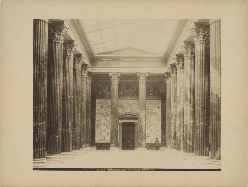 Blick in die Säulenhalle, noch ohne Luster. Blick Richtung Empfangssalon.
 
Über der Tür zum Empfangssalon befindet sich noch der Entwurf für den Fries, den Lebiedzki 1883 in Anlehnung an ein Friesgemälde von Carl Rahl anfertigte.