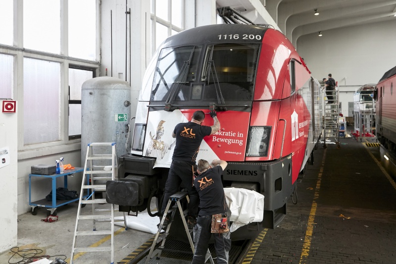 Beklebung der ÖBB-Lok mit dem Motiv: 'Demokratie in Bewegung'
